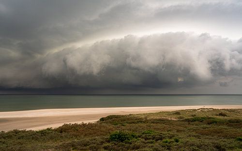 De naderende storm: Een dramatische scène op een Nederlands strand
