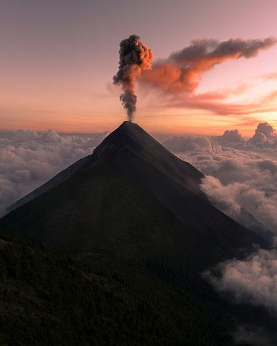 Vurige adem boven de wolken Volcán de Fuego bij zonsondergang