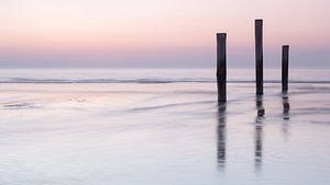 Strandpalen in het water in pasteltinten