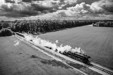 Steam train with smoke from the locomotive driving through a field by Sjoerd van der Wal Photography