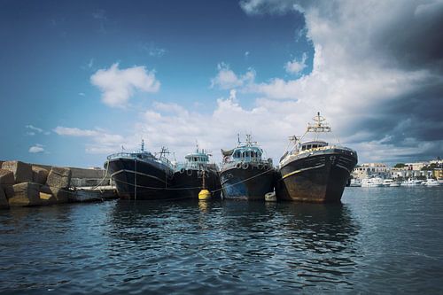 Drie Boten in de Haven van Lampedusa: Dynamisch Havenbeeld voor Uw Interieur