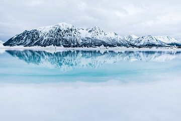 Réflexion d'une chaîne de montagnes dans une eau bleu clair sur Martijn Smeets