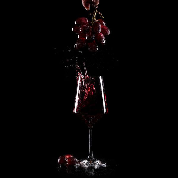 Weintraubenspritzer in einem Glas Rotwein von Petra Niessen