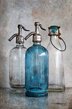 bottles on concrete by Harald lakerveld