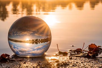 Le soleil se lève à travers une boule de verre. sur Els Oomis