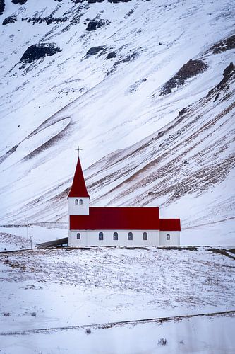 Weiße Kirche mit rotem Dach in einer verschneiten Landschaft, Vík, Island