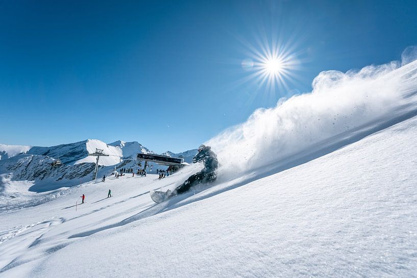 Snowboarders in powder snow in sunshine and powder snow by Leo Schindzielorz