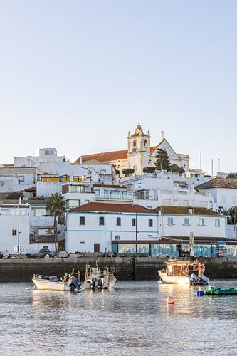 Zandstrand in de ochtend met uitzicht op het historische centrum van Ferragudo, Portimão, Algarve, Portugal
