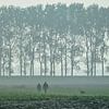 Mistige ochtend met twee wandelaars met hond in de Zeeuwse polder van Gert van Santen
