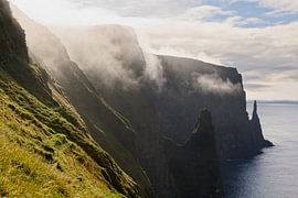 Mist drifts away over the cliff-lined coast