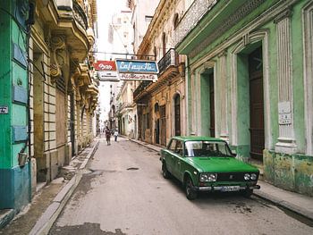 Authentic street in Havana in Cuba with green oldtimer car parked