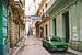 Authentieke straat in Havana op Cuba met groene oldtimer auto geparkeerd van Michiel Dros