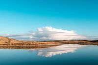 Weiße Wolke über den Dünen mit Spiegelbild im Wasser
