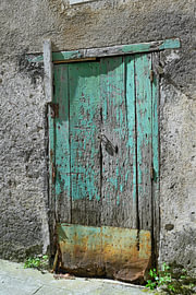 Alte Holztür mit abblätternder Farbe und verwitterter Oberfläche von Tomherkules