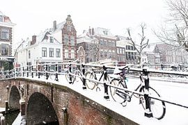 Winter in Utrecht. Besneeuwde Geertebrug over de Oudegracht  vol met fietsen. van André Blom Fotografie Utrecht