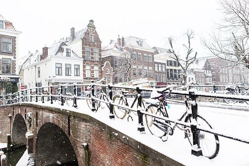 Winter in Utrecht. Besneeuwde Geertebrug over de Oudegracht  vol met fietsen.