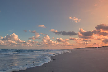 Opkomende herfstzon op het strand