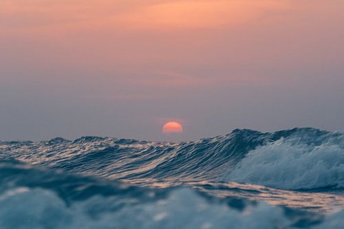 Zonsondergang boven de hoge golven van de Noordzee bij Terschelling