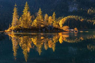 Small island on the Eibsee in Bavaria at the foot of the Zugspitze at sunrise in autumn