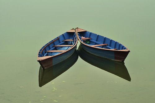 Boten op het gouden water. Boten zijn vastgebonden aan de pijlers van het kalme water.