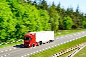 Semi truck driving on a highway through nature