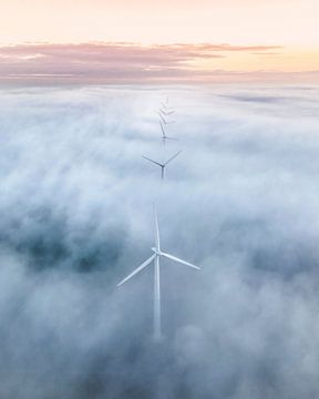 Windräder über einem Meer aus Nebel von Ewold Kooistra