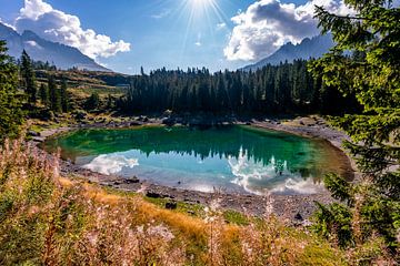 Lac Carezza avec des fleurs et des rayons de soleil sur Dafne Vos