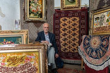 Potrait van de Iraanse man in zijn tapijtwinkel