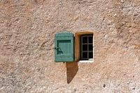Window in old French rural house. Green shutters  and terracotta wall