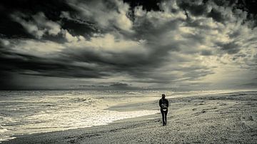 Man lonely on beach with storm clouds in black and white by Dieter Walther