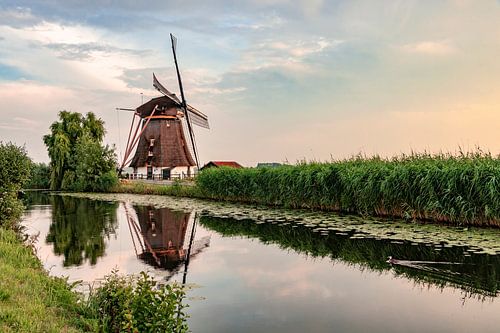 Mill in picturesque Dutch landscape by quiet water