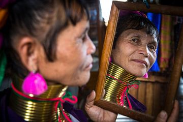 Vrouw behorende tot de long neck tribe in Inle bekijkt zichzelf 