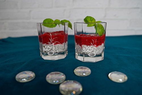 Dessert met frambozenpuree geserveerd in een glas