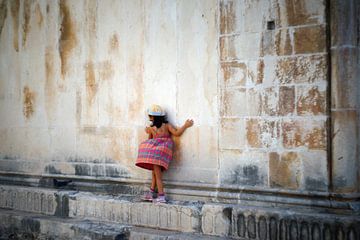 Een meisjes balanceert op een richel van een oud gebouw van Floris Verweij