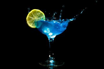 Blue curacao cocktail splash with a slice of lemon by Eye on You