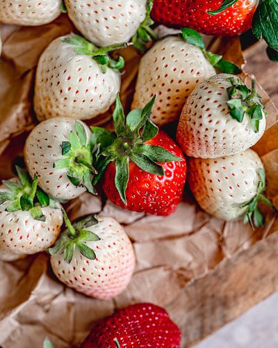 White and red strawberries on a wooden board from Myanmar