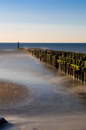 Golfbreker aan het strand in het water.