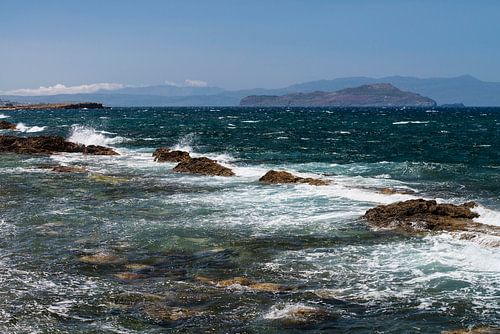 Vergezicht over de zee met rotsen in de branding