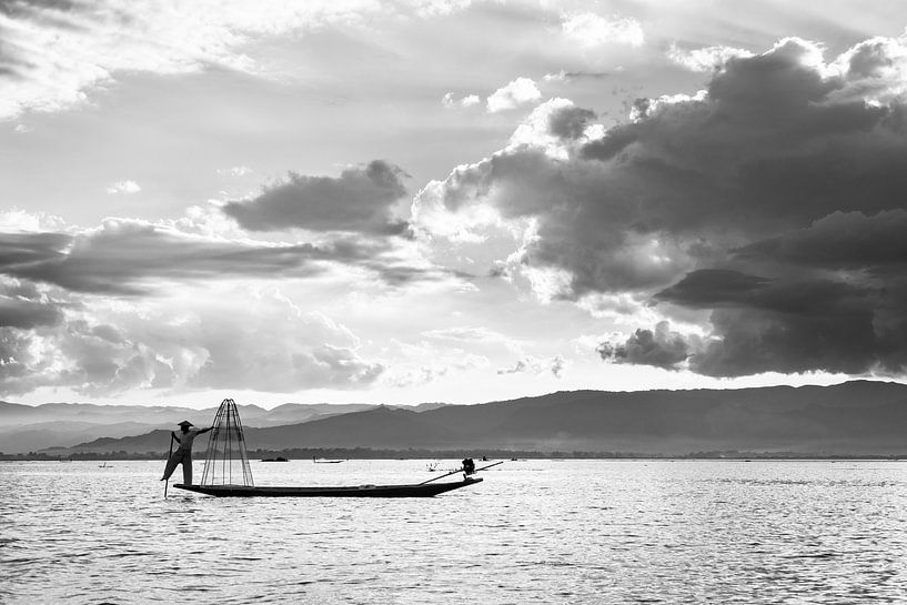 Zwart-wit foto van een visser met zijn visnetten op de boot op het Inle meer in Myanmar van Twan Bankers