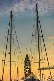 The wooden clock of Hindeloopen harbour in the light of sunset by Harrie Muis