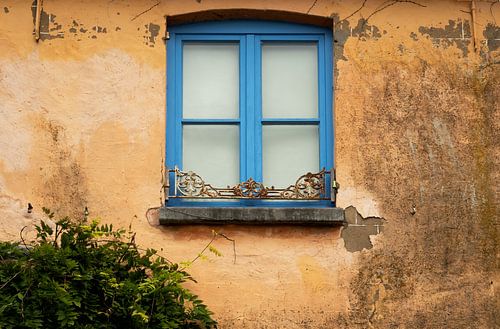 Mediterranean wall with blue window frame.