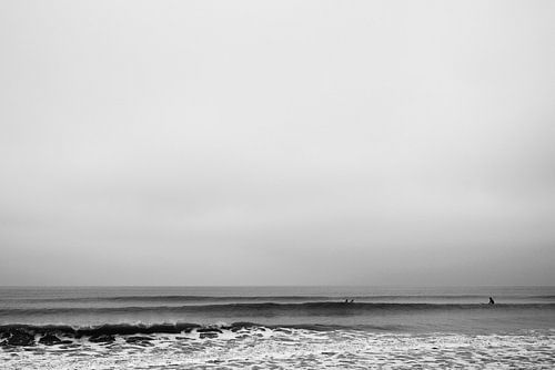 Surfers in een kalme zee - zwart wit
