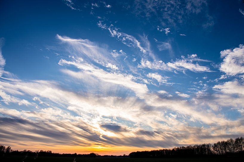 Wolkenluchten boven Drente met een ondergaande zon. van Brian Morgan