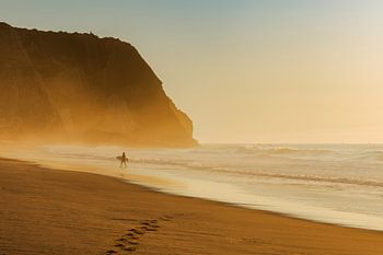 Einsamer Surfer am Strand bei Sonnenuntergang
