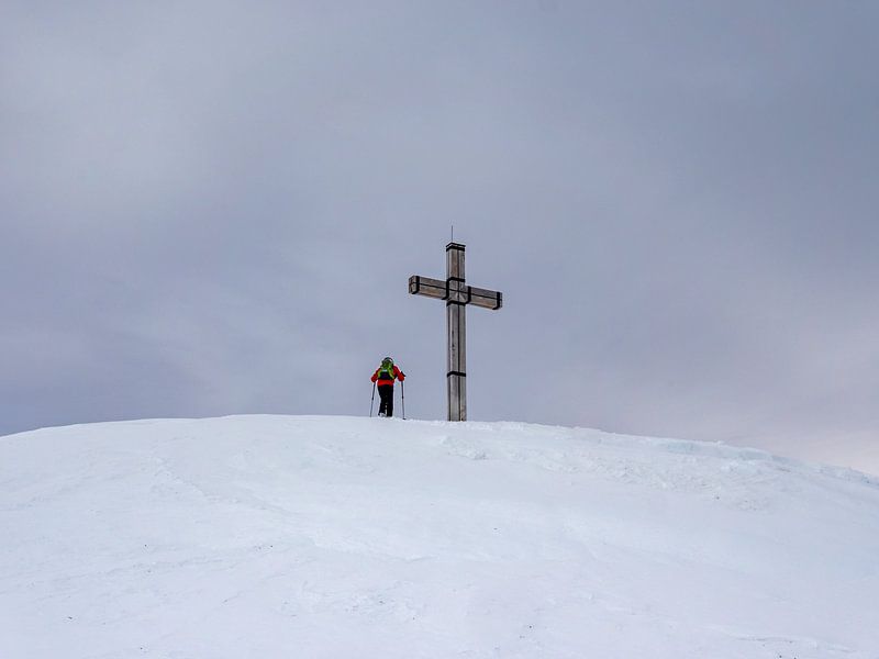 Mountaineer on a summit cross in the Alps by Animaflora PicsStock