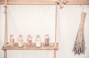 Foto van een houten plankje met flesjes en lavendel. van Frans Scherpenisse