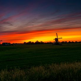 deux moulins à vent au lever du soleil aux Pays-Bas. sur Ruurd Dankloff