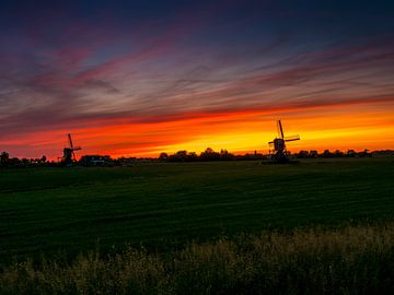 twee windmolens bij zonsopgang in Nederland. van Ruurd Dankloff