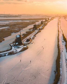 Ice skating at Kinderdijk in Golden Light by Ewold Kooistra