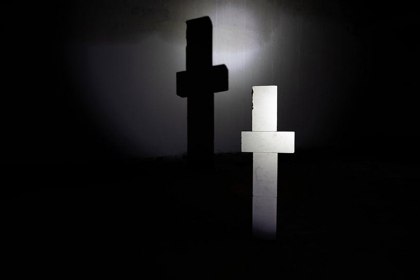 Weisses Kreuz mit Schatten in der Dunkelheit von Frank Herrmann